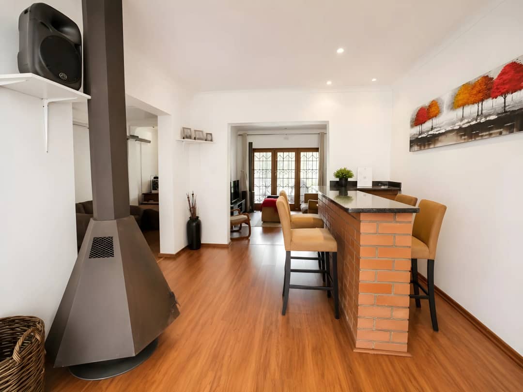 Indoor bar with a brick-faced counter, bar stools and a freestanding cone fireplace